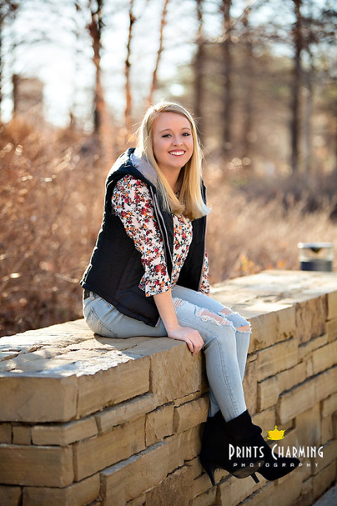 McKinsey high school senior portraits outdoors smiling and sitting on stone wall by brown grasses McKR_5499